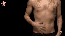 a man without a shirt is holding his stomach and the number 3 is visible