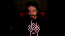 a man with a beard is wearing a black shirt with a white spider web on it