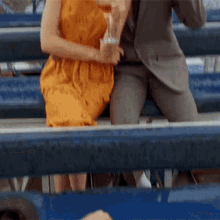 a man and a woman sit on a blue bench