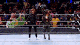 two men are standing in a wrestling ring giving each other a high five .