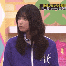 a girl wearing a purple jacket with the number 46 on the front