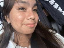 a close up of a woman 's face with a white shirt behind her