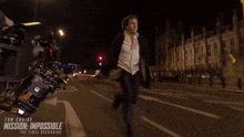 a woman is running down a street in front of a sign that says mission impossible the final reckoning