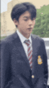 a young man in a suit and tie is standing in a parking lot .