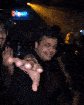 a man reaches out his hand in front of a sign that says dj