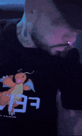 a man with a beard wears a black shirt with a dragon on it and the word fear on it