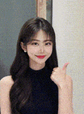 a young woman in a black top is giving a thumbs up .