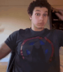 a young man wearing a black t-shirt with a captain america logo on it