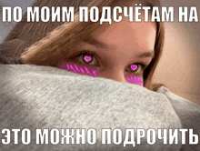 a girl with hearts painted on her eyes looks over a grey blanket