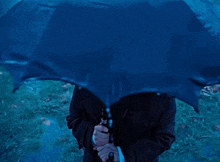 a man in a suit and tie is holding an umbrella in the rain