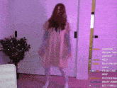a woman in a pink dress is dancing in front of a purple wall with a purple background