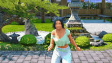 a woman in a green top and white pants is standing on a brick walkway