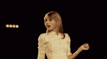 a woman in a white lace shirt is standing on a stage .