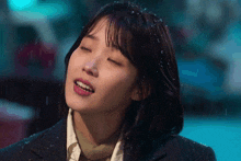 a close up of a woman 's face with snow falling on it