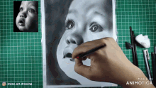a person is drawing a baby 's face with a pencil