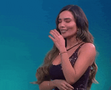 a woman in a purple dress covers her mouth with her hand