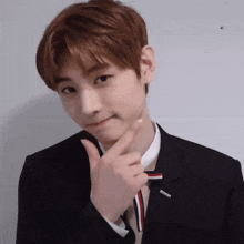 a young man in a suit and tie is making a face