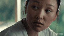 a close up of a woman 's face with the word netflix on the bottom right