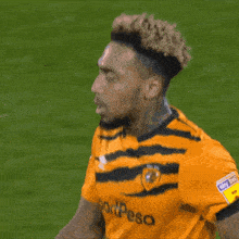 a soccer player wearing a yellow and black jersey that says sportpesa