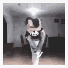 a man is carrying a woman on his back in a room .