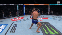 two men are fighting in a boxing ring sponsored by espn