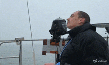 a man stands on a boat with a yamaha outboard motor in front of his face