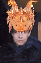 a man wearing a dragon mask with flames on his head