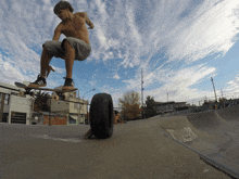 a skateboarder is doing a trick with a tire in the background