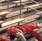 a cheerleader is laying on the bleachers wearing a uniform that says ' miami ' on it