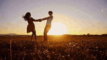 two women dancing in a field at sunset