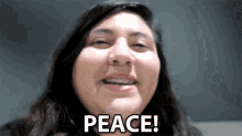 a woman is smiling with the words peace written on her face