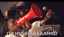 a woman is holding a red megaphone in her mouth and shouting into it .