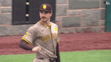 a baseball player in a san diego uniform is standing on a baseball field .