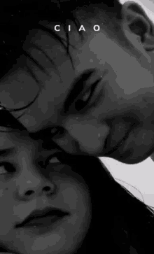 a black and white photo of a man and a woman looking at each other .