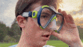 a young man wearing a diving mask with the text " the tech " on the bottom right