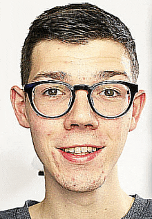 a young man wearing glasses is smiling at the camera .