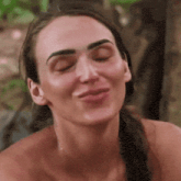 a woman without a shirt is making a face with her eyes closed