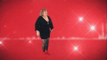 a woman wearing a black top and a necklace is dancing