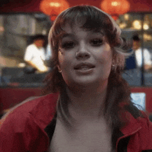 a close up of a woman wearing a red jacket .