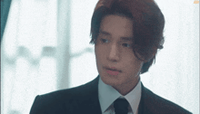 a man in a suit and tie is looking at something