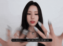 a woman wearing a necklace with a heart shaped pendant has won hwayeon written on the bottom right