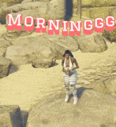 a woman stands on a rock in front of a sign that says morninggo