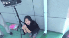 a girl is sitting on the ground with the word joon on the bottom