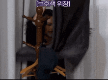a woman is standing in a closet behind a clothes rack with chinese writing on the bottom right