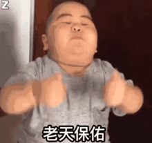 a fat baby is giving a thumbs up sign with his hands in the air .