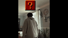 a man standing in a living room with a question mark on the wall above him