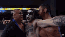 a group of men are hugging each other and one of them has a tattoo on his chest that says roh