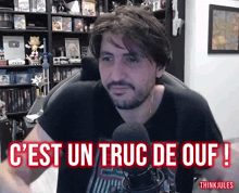 a man sitting in front of a microphone with the words " c'est un truc de ouf " written above him