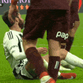 a soccer player wearing a pap shorts is laying on the ground