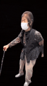 an elderly woman wearing a mask and a cane